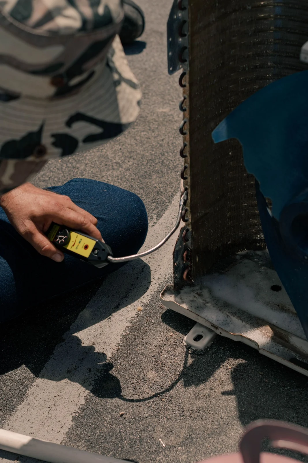 Hands servicing an outdoor air conditioning unit